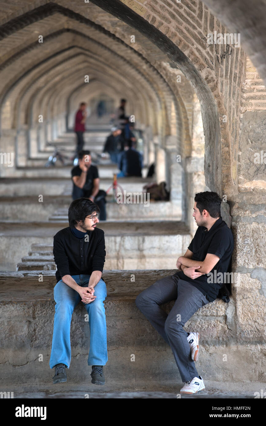 People gathering under the arches of Si-o-seh Pol Bridge, Isfahan, Iran Stock Photo