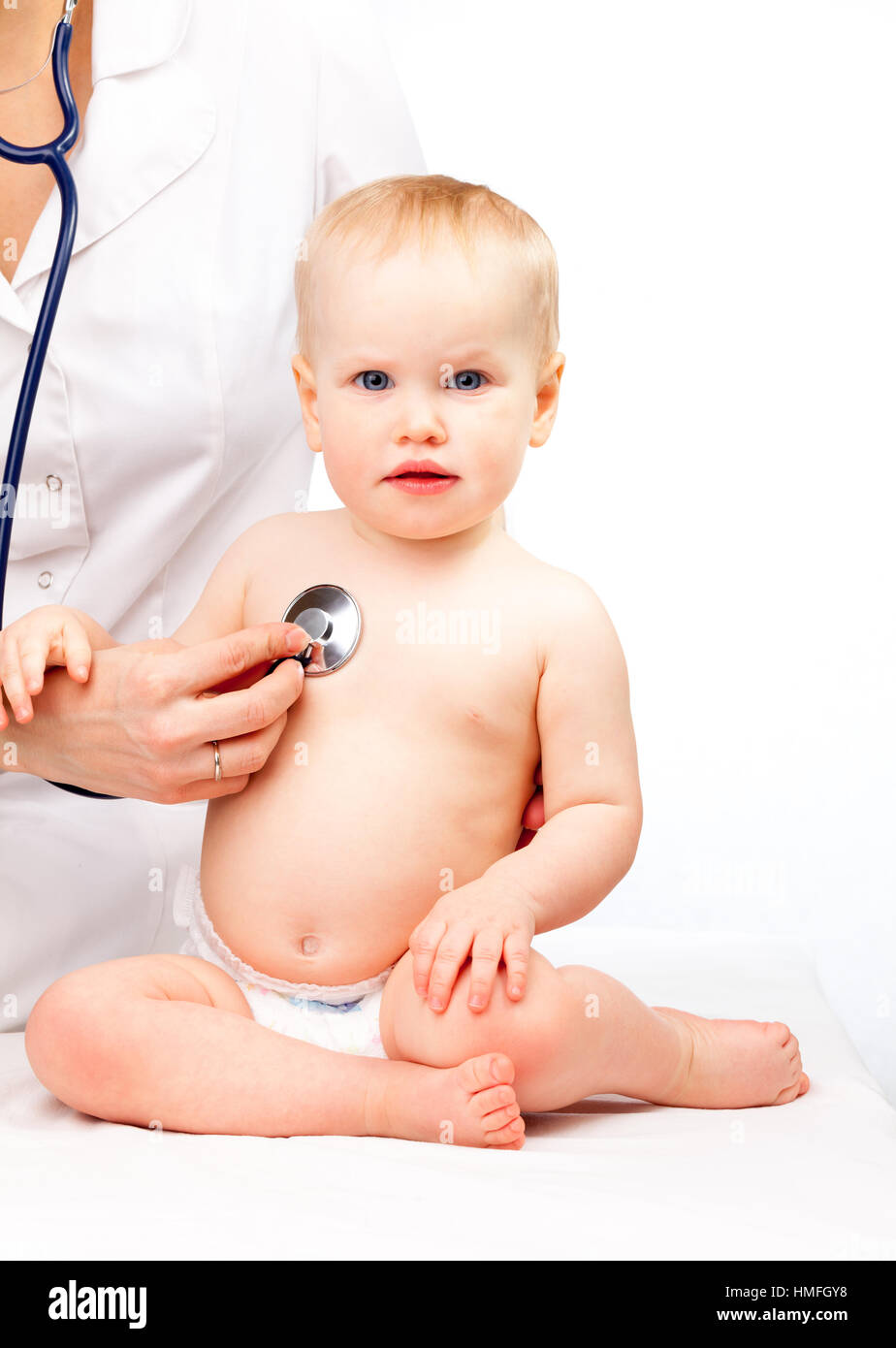 Pediatrician examines little baby girl using a stethoscope to listen to baby's chest checking heart beat Stock Photo