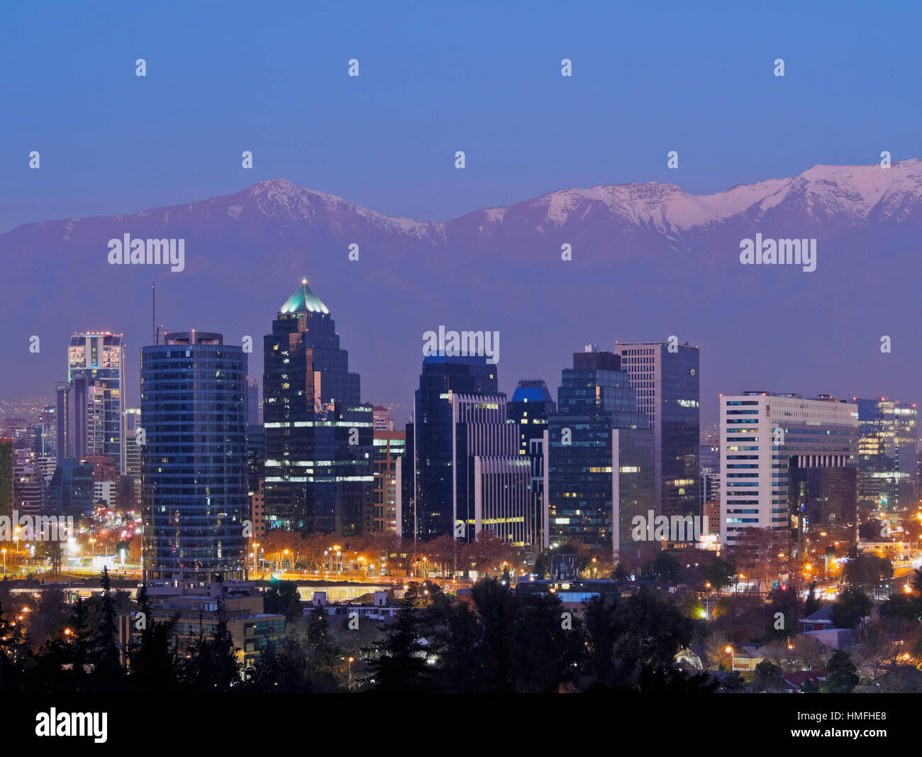 Twilight view from the Parque Metropolitano towards the high rise buildings, and snow covered mountains behind, Santiago, Chile Stock Photo