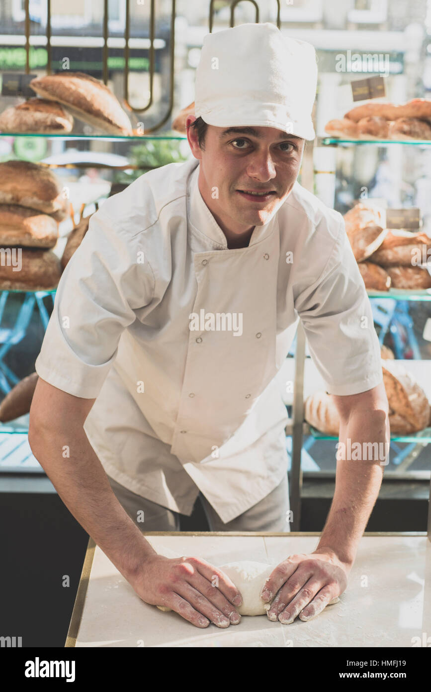 a professional chef prepares and cooks loafs of bread and baking products  in a clean and fresh modern kitchen wearing chefs uniform / clothing Stock  Photo - Alamy