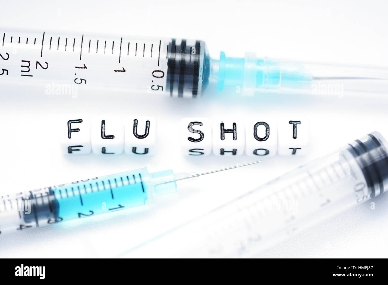 Flu shot text spelled with tiled plastic letters standing next to a syringe Stock Photo