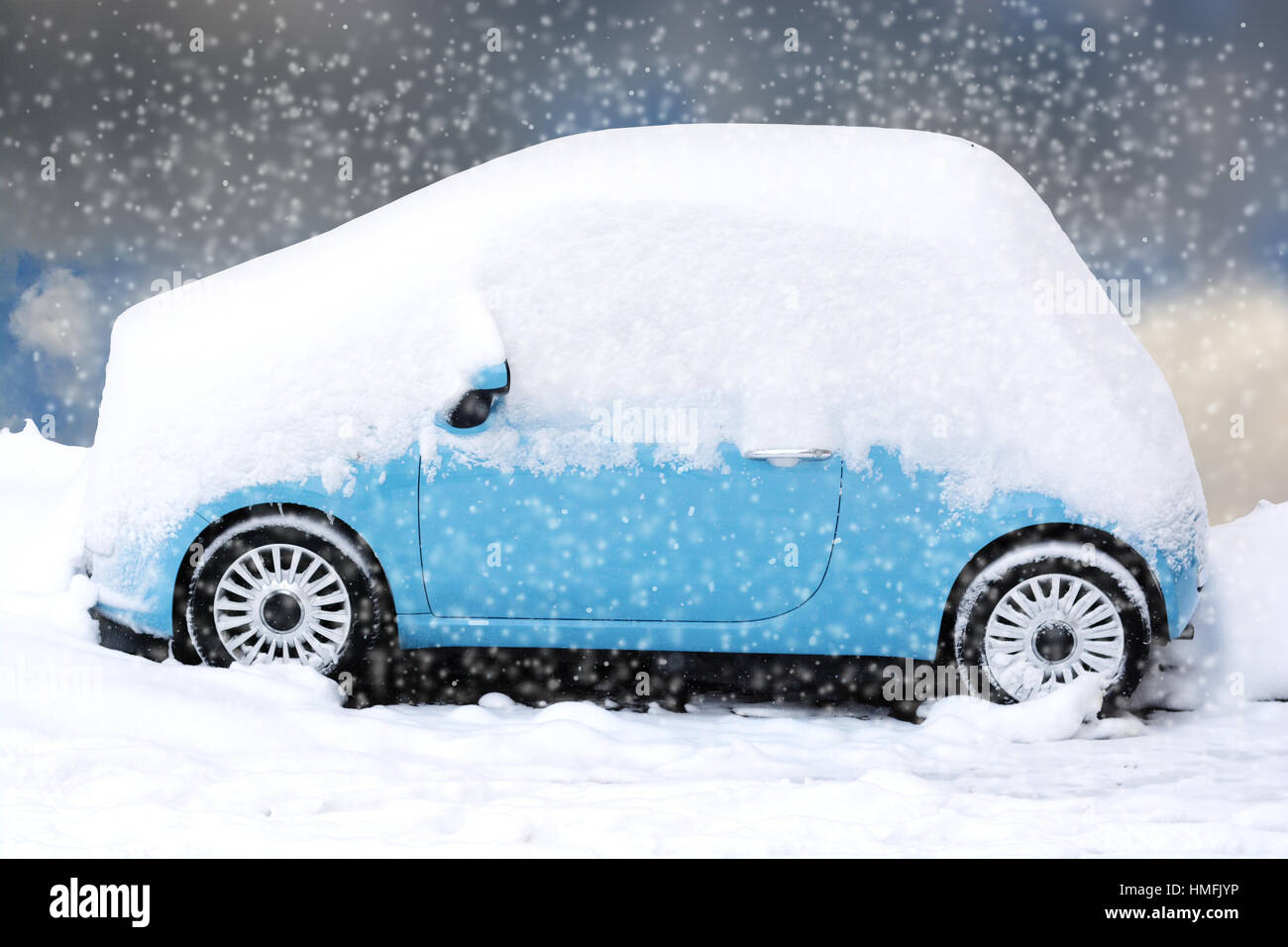 Blue car covered and surrounded by snow drifts after a snow storm Stock Photo