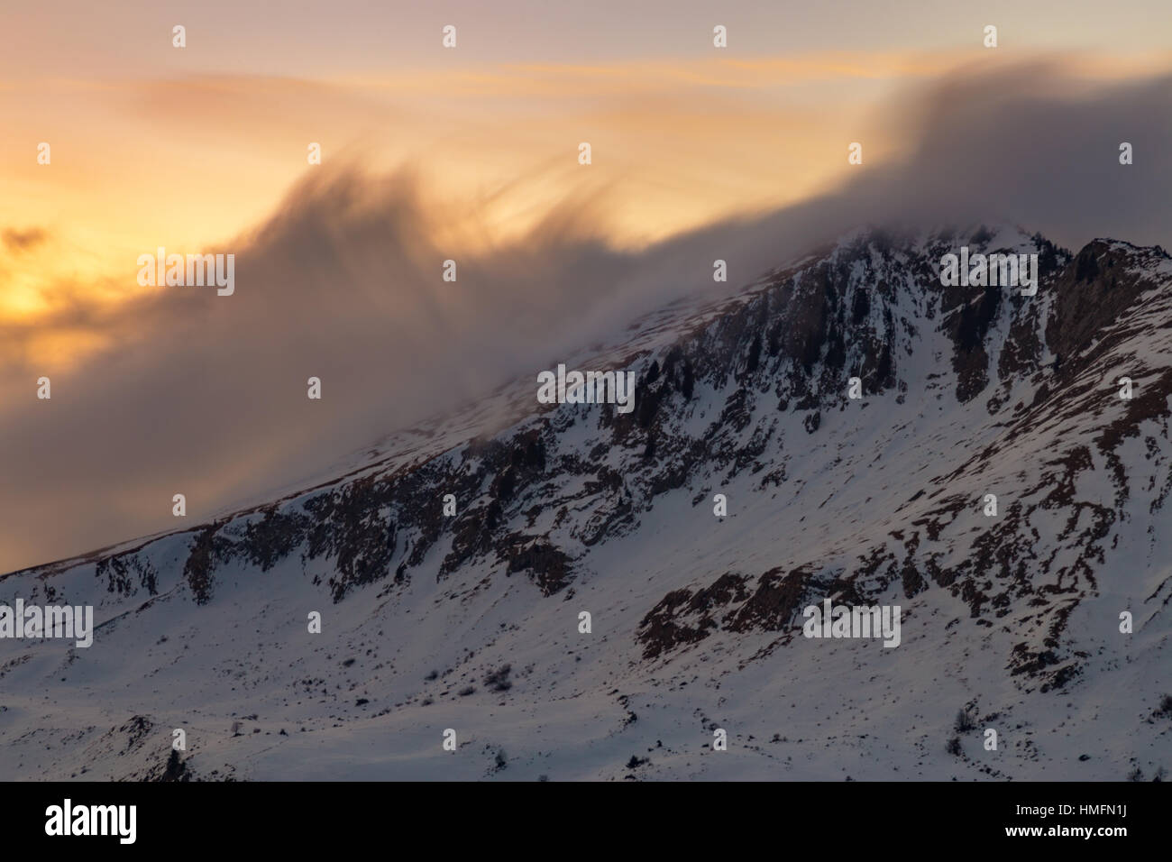 Vibrant orange sunset over snowy mountains in the Alps Stock Photo - Alamy