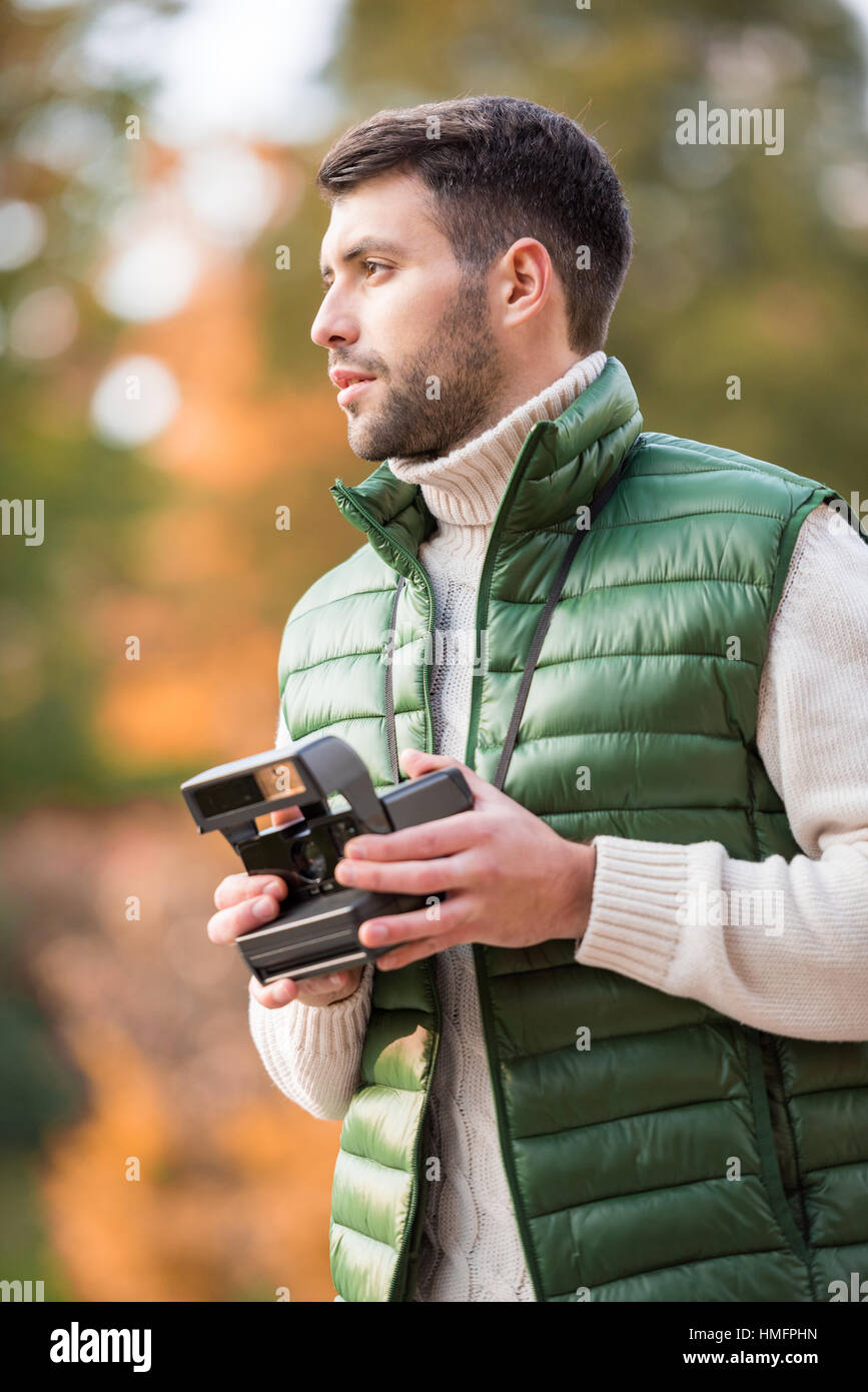 Handsome man holding instant camera Stock Photo