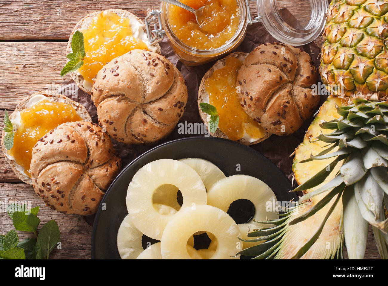 pineapple jam in a glass jar and sweet sandwiches closeup on the table