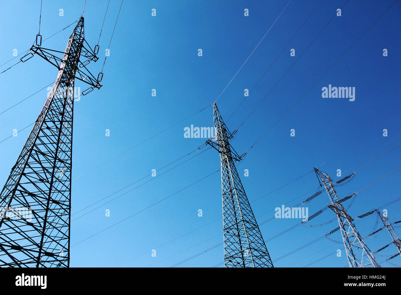 big high voltage electric towers under blue sky Stock Photo