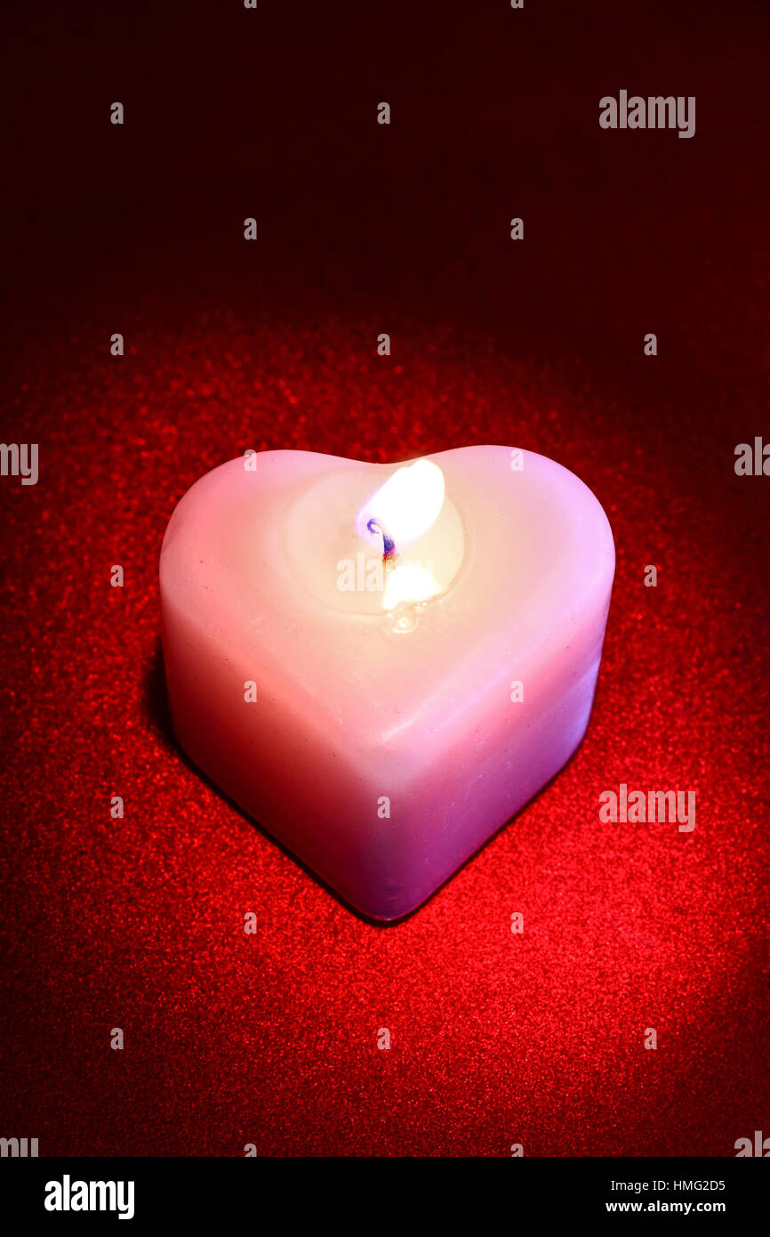 Heart shaped wax candle isolated on a red background Stock Photo Alamy