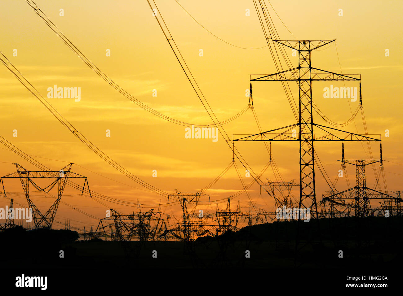 field of high voltage towers under dramatic sky Stock Photo - Alamy