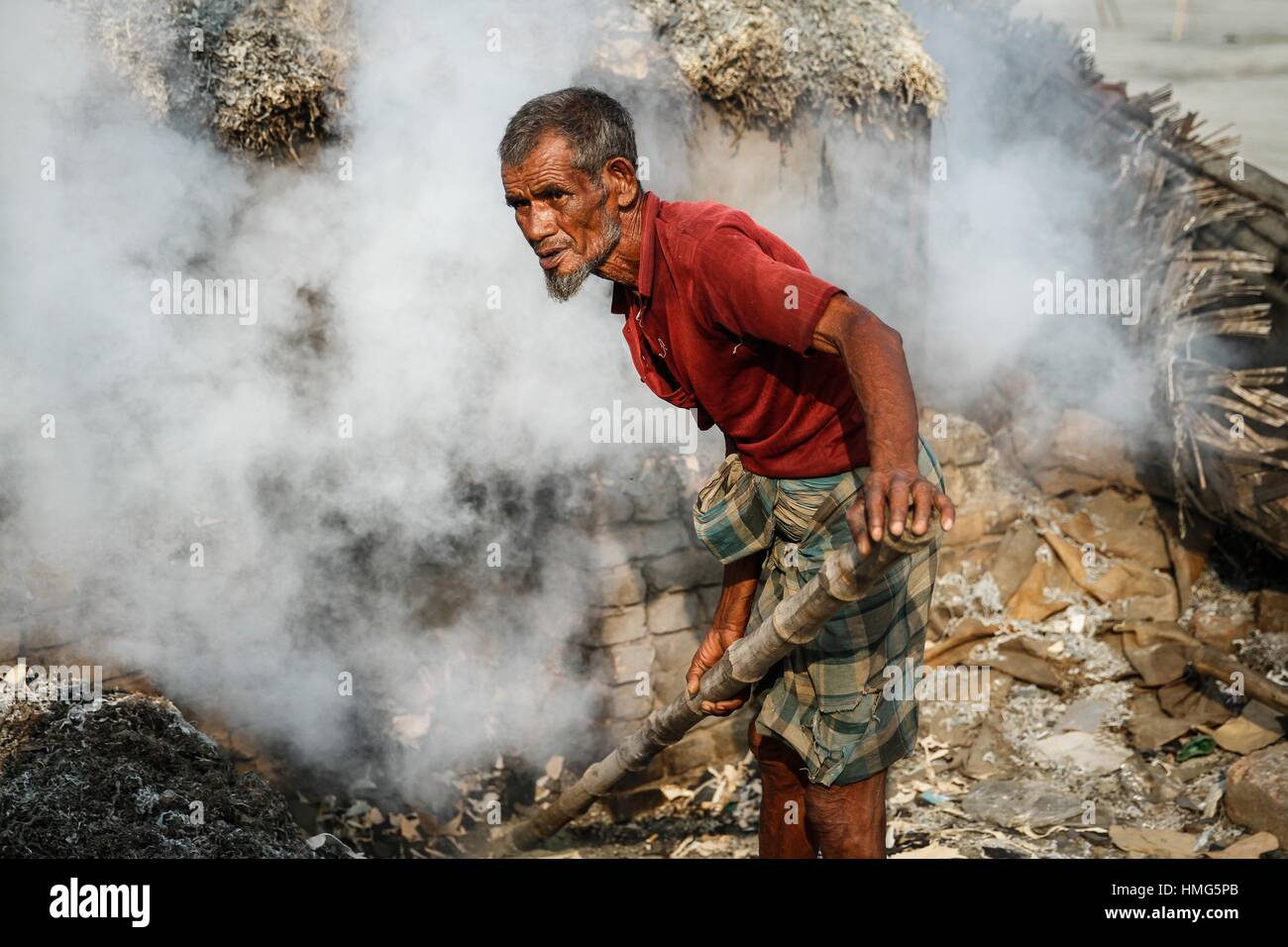 A man processes tannery wastes to make poultry feed at Hazaribagh along the polluted Buriganga river in Dhaka. Stock Photo