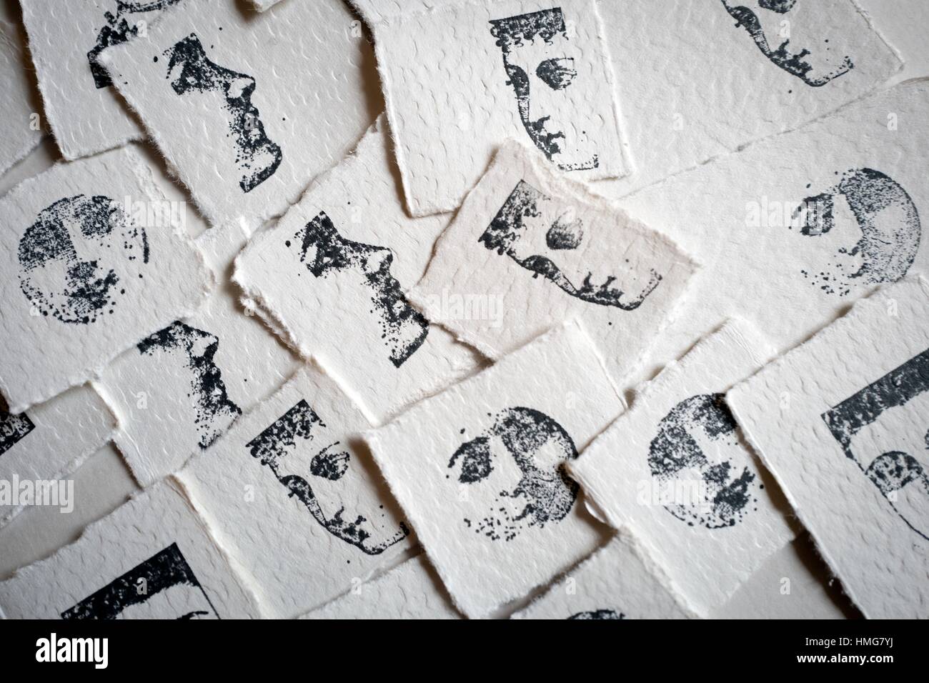 Multi image of rubber stamp lady faces stamped in pieces of paper Stock