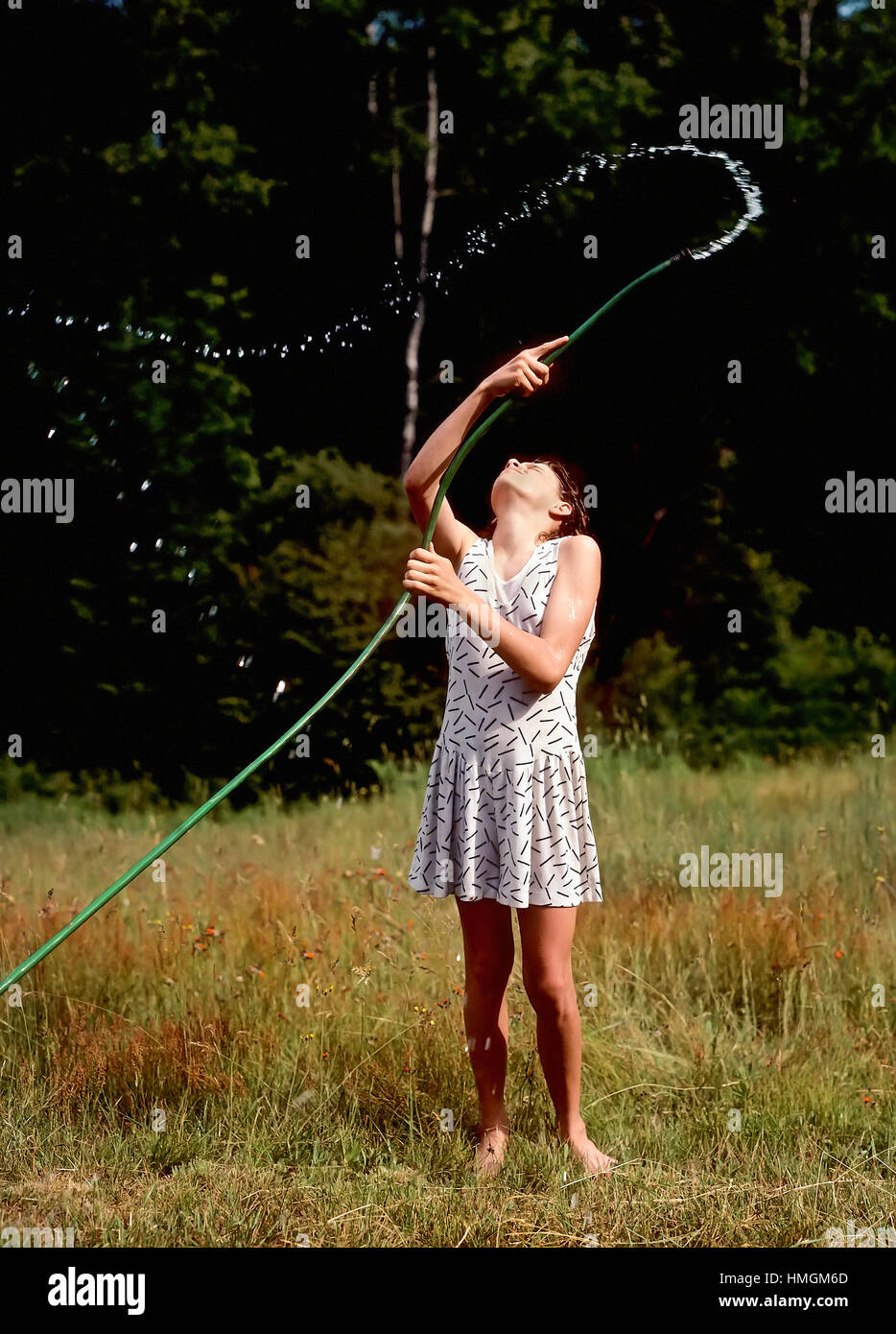 Young girl squirts water into the air. USA Stock Photo