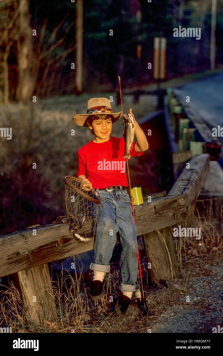 A ten year old boy proudly holds up his first ever trout that he caught in a stream at Plainfield, New Hampshire, United States. Stock Photo
