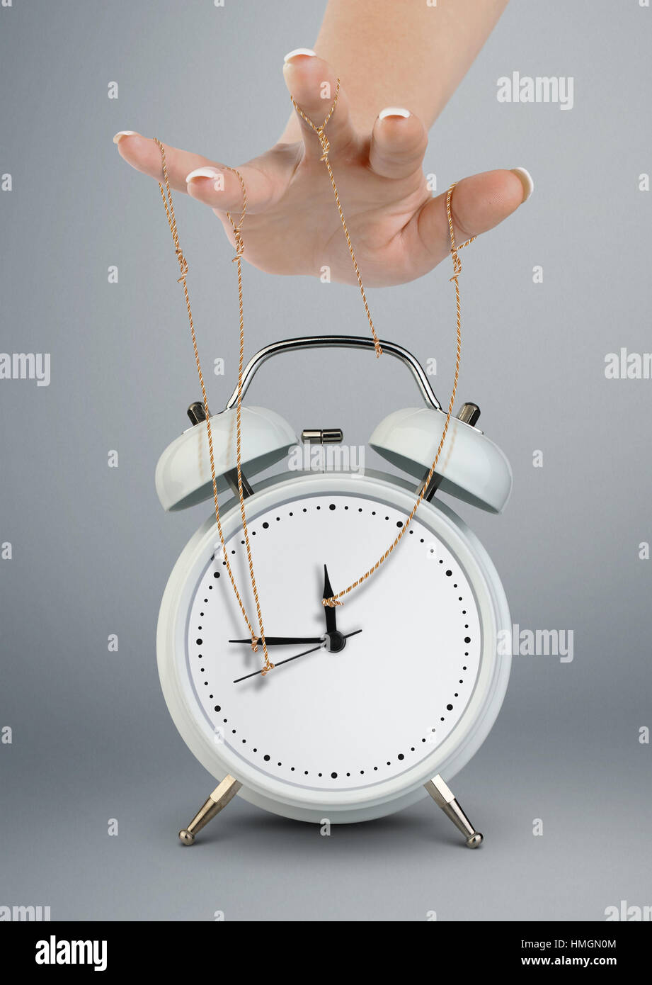 Hand puppeteer manipulating alarm clock, time management concept Stock Photo