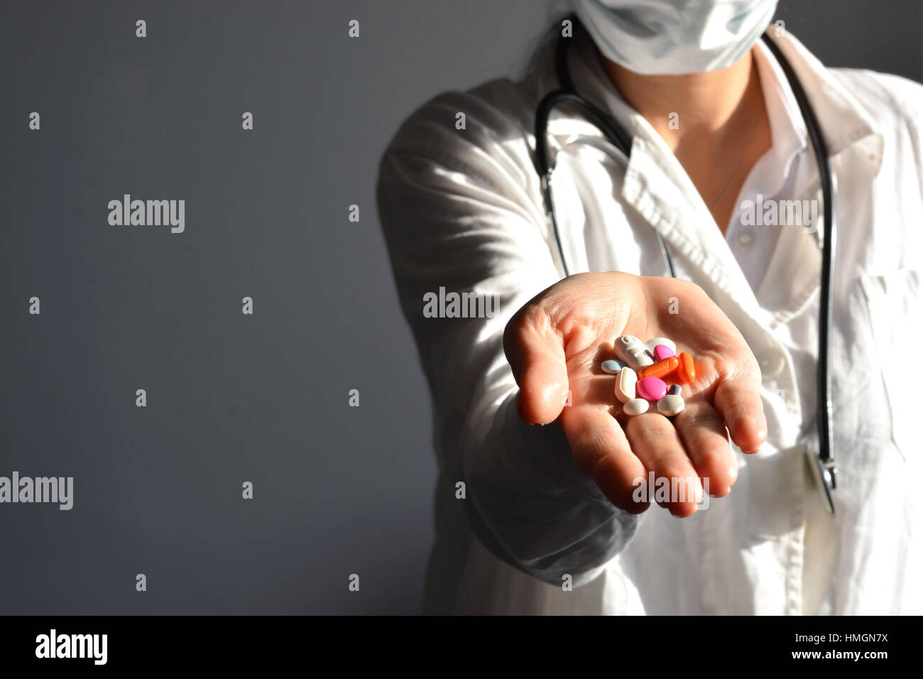 Female doctor displaying a handful of tablets and pills in her palm Stock Photo