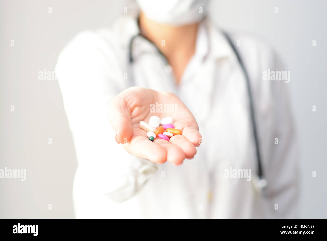 Female doctor displaying a handful of tablets and pills in her palm Stock Photo
