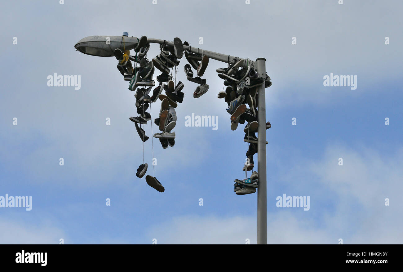 Tennis shoes hang from lightpost. Stock Photo