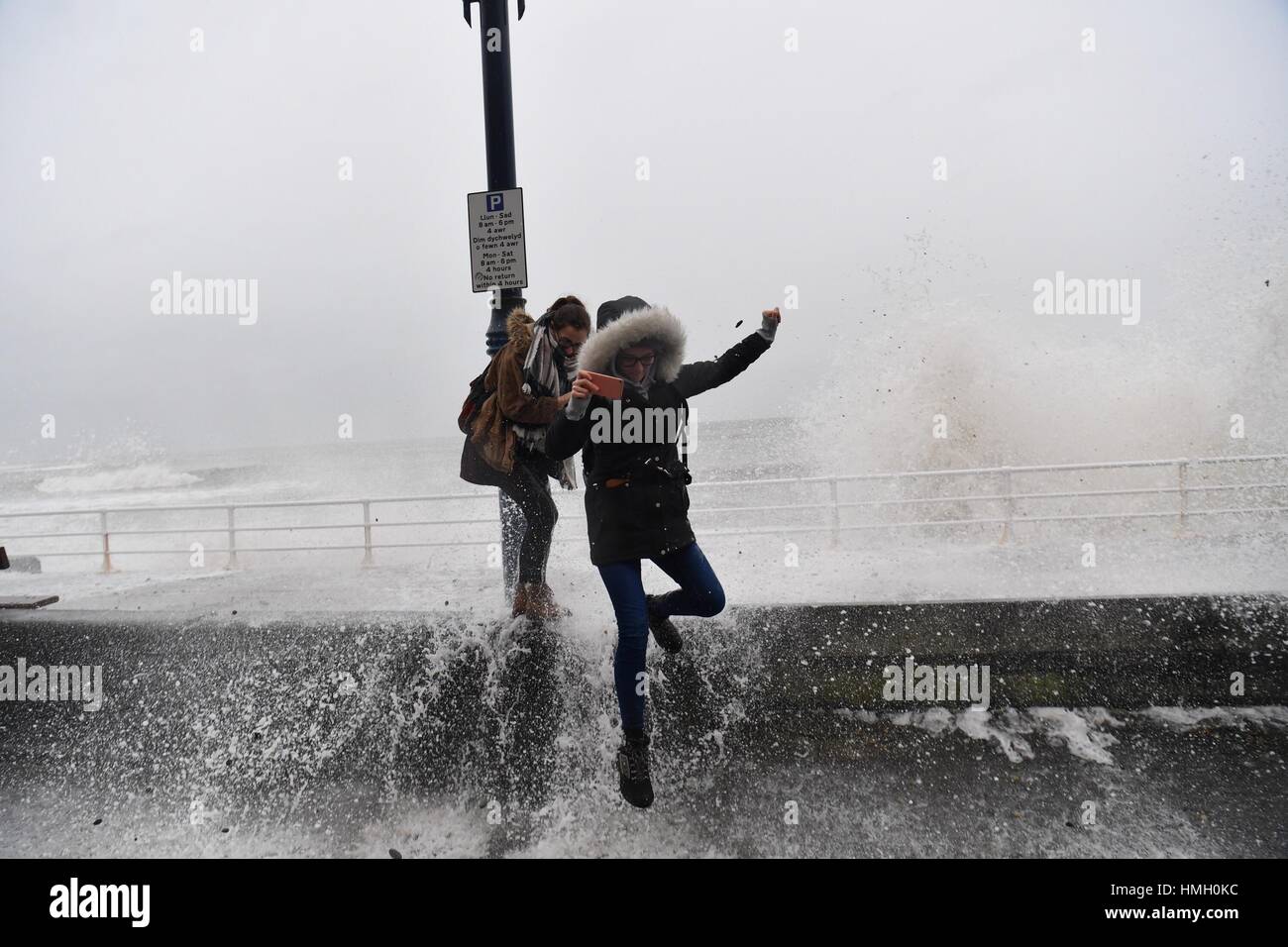 Aberystwyth, Ceredigion, Wales, UK. 3rd Feb, 2017. UK Weather. Two young women get soaked by the waves as high tides and a strong Atlantic swell this morning bring huge waves crashing into the promenade and sea defences in Aberystwyth on the west wales coast. Potentially damaging gales, with gusts in excess of 60mph are forecast to strike parts of southern UK today photo Credit: keith morris/Alamy Live News Stock Photo
