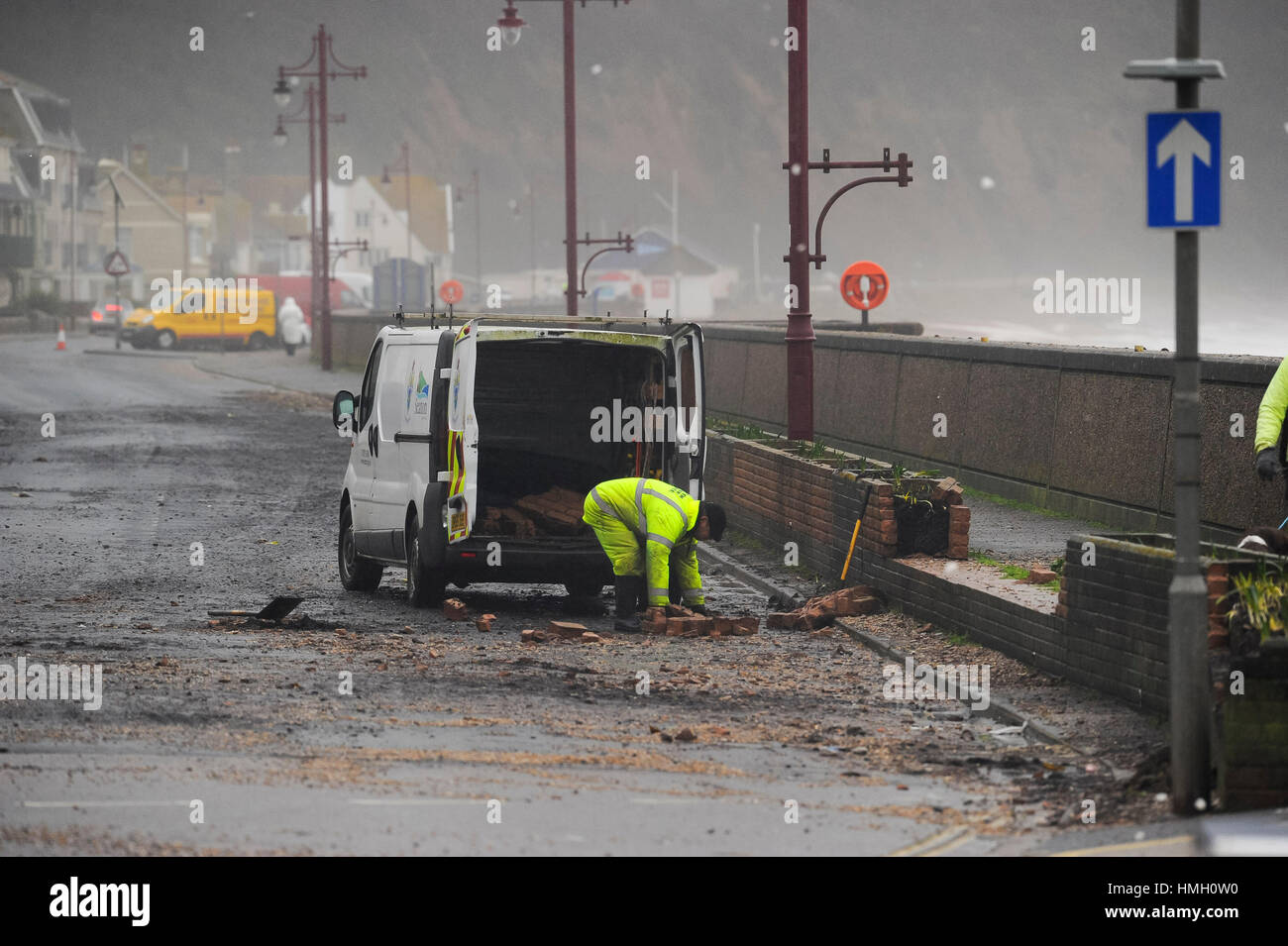 Seaton, Devon, UK.  3rd February 2017.  UK Weather.  A workman clearing up debris from a damage section of wall on the seafront at Seaton in Devon, after waves from the storm overtopped the sea wall during night.  Photo by Graham Hunt/Alamy Live News Stock Photo