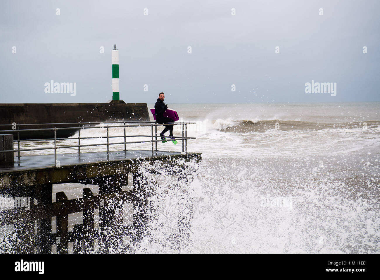 Aberystwyth, Ceredigion, Wales, UK. 3rd Feb, 2017. UK Weather. High tides and a strong Atlantic swell this morning bring huge waves crashing into the promenade and sea defences in Aberystwyth on the west wales coast. A brave body-boarder takes the opportunity of riding some of the huge 10' high waves as they break near Aberystwyth harbour Potentially damaging gales, with gusts in excess of 60mph are forecast to strike parts of southern UK today photo Credit: Keith Morris/Alamy Live News Stock Photo