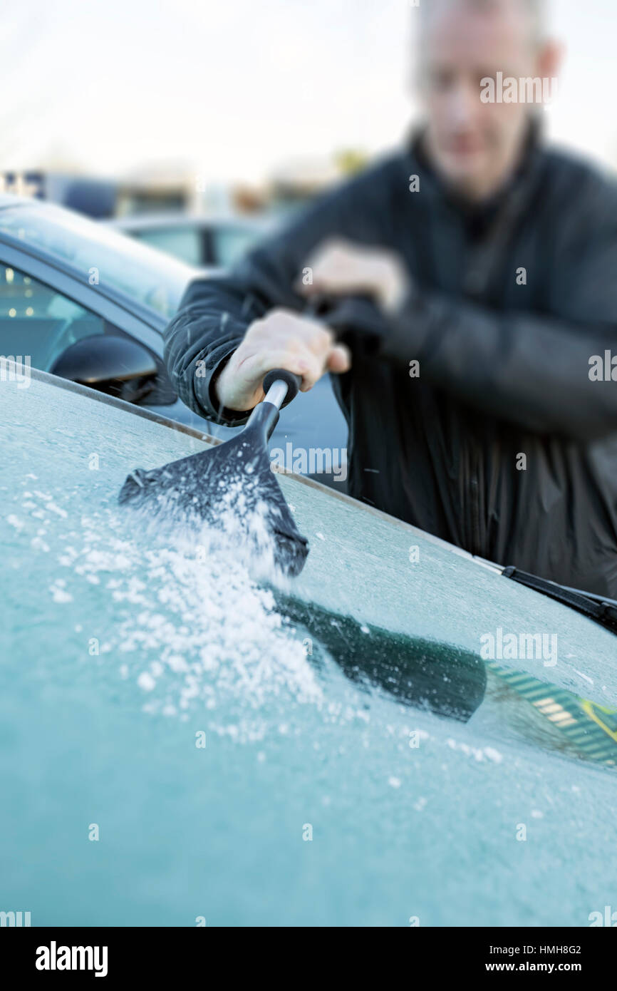 Person deicing car windscreen with hand scraper Stock Photo Alamy