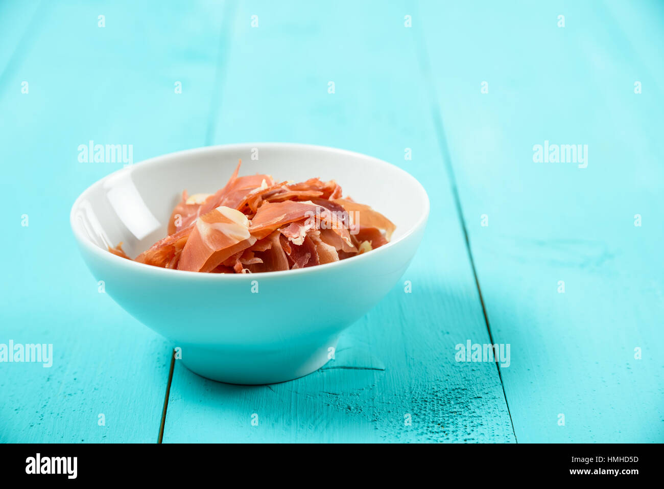 Fresh Bacon In White Bowl On Turquoise Table Stock Photo