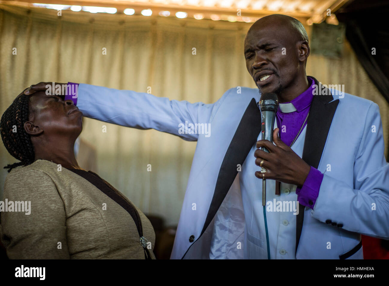 Pastor Chibwe Katebe exorcises the evil spirit from the body of a woman during a Sunday service at the House of Prayer for All Nations in Livingstone, Zambia Stock Photo