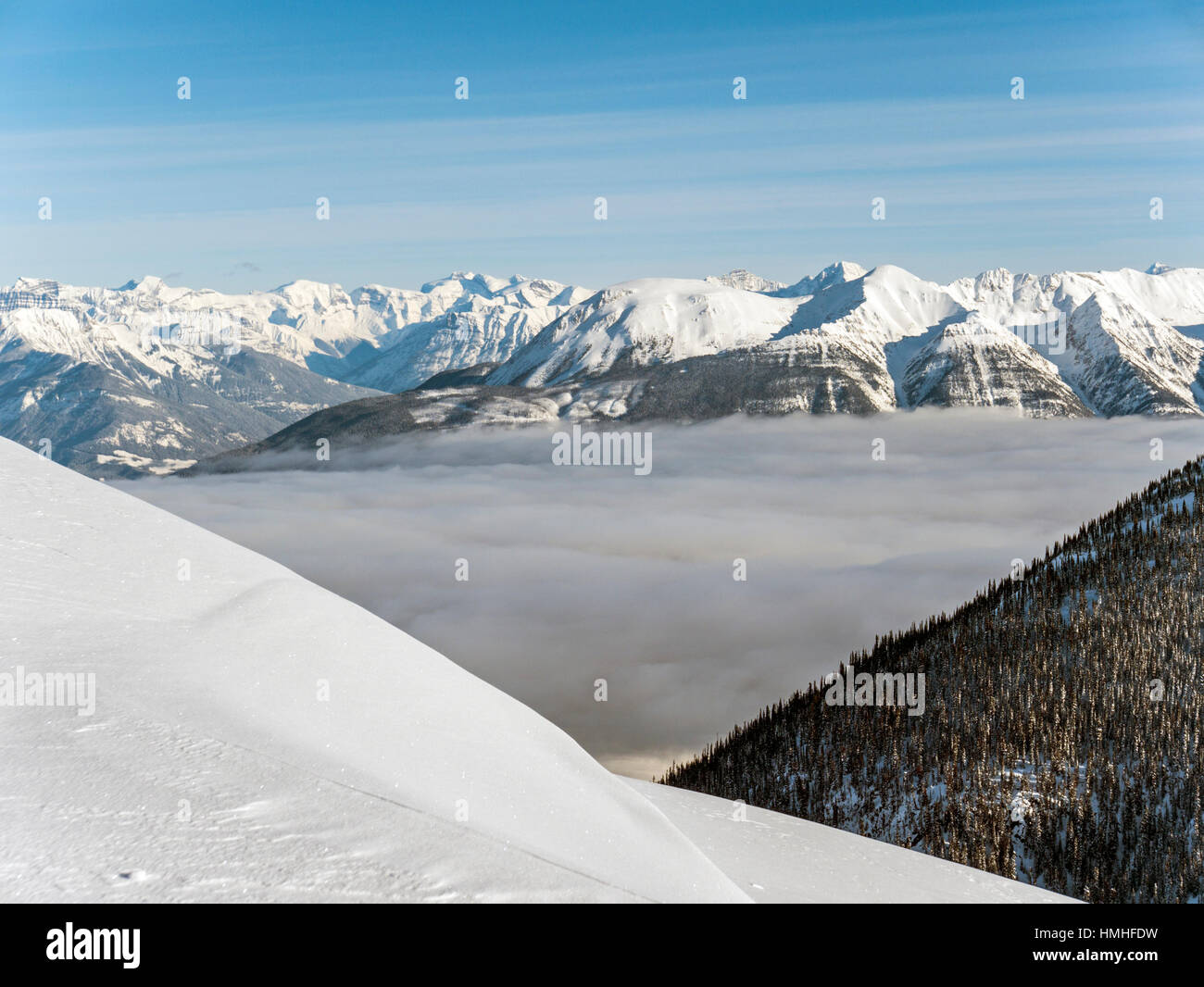 Snowy winter mountain landscape with fog filled valley; Esplanade Range; Selkirk Range; British Columbia; Canada Stock Photo