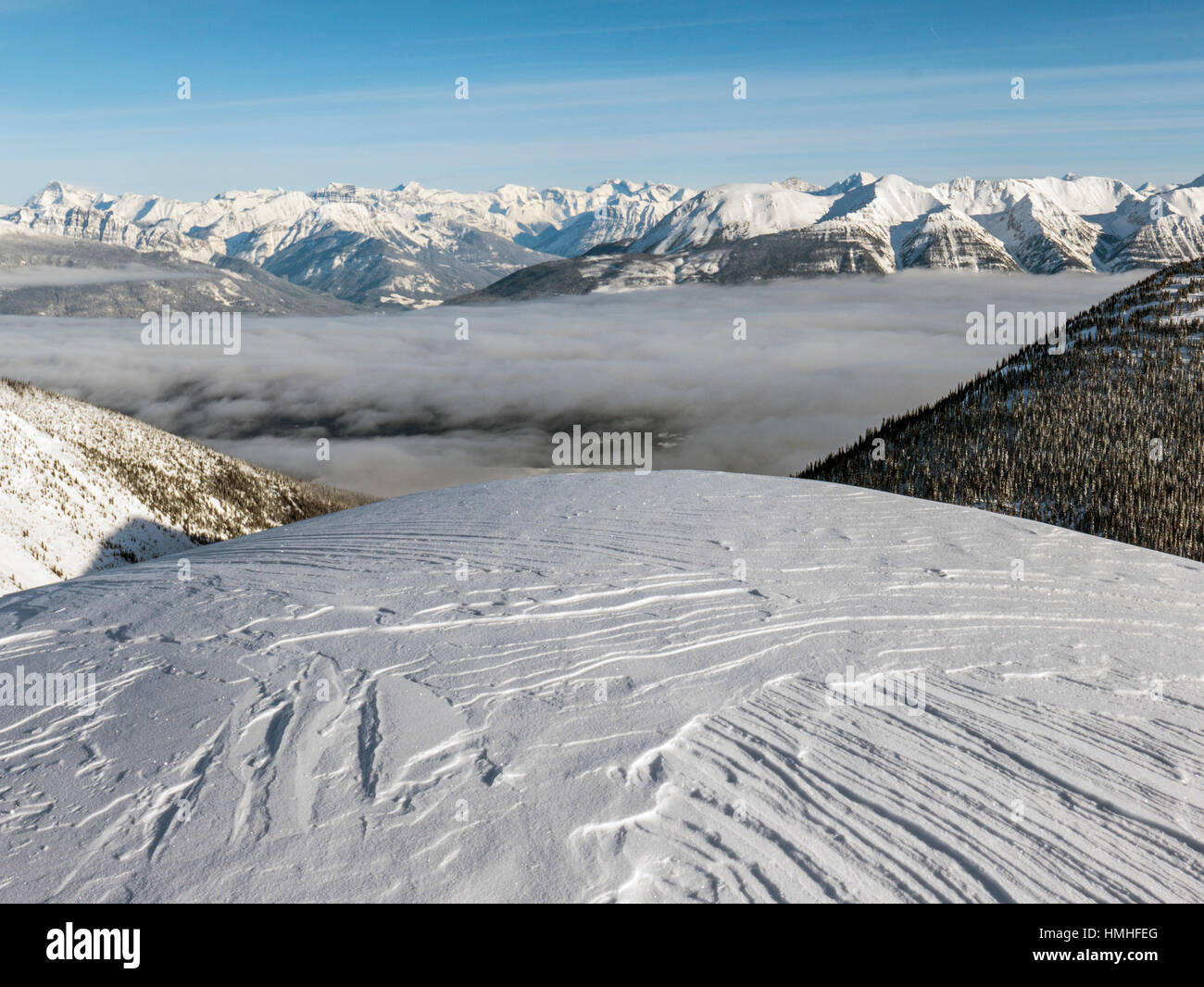 Snowy winter mountain landscape with fog filled valley; Esplanade Range; Selkirk Range; British Columbia; Canada Stock Photo