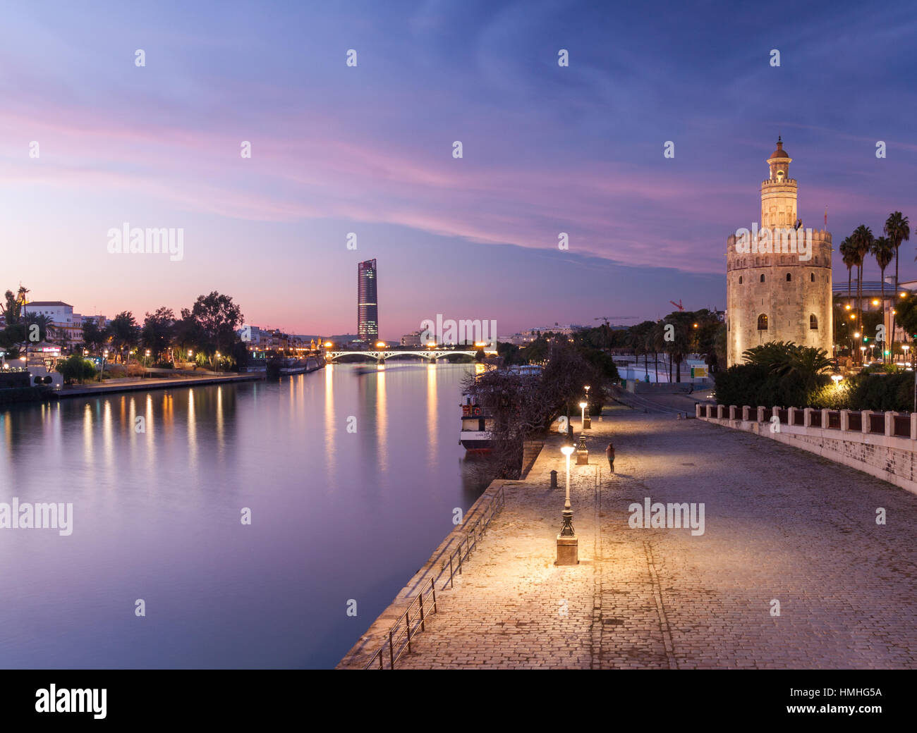 Views from Puente de San Telmo of the Torre del Oro, Torre Sevilla and Río Guadalquivir at dusk Stock Photo