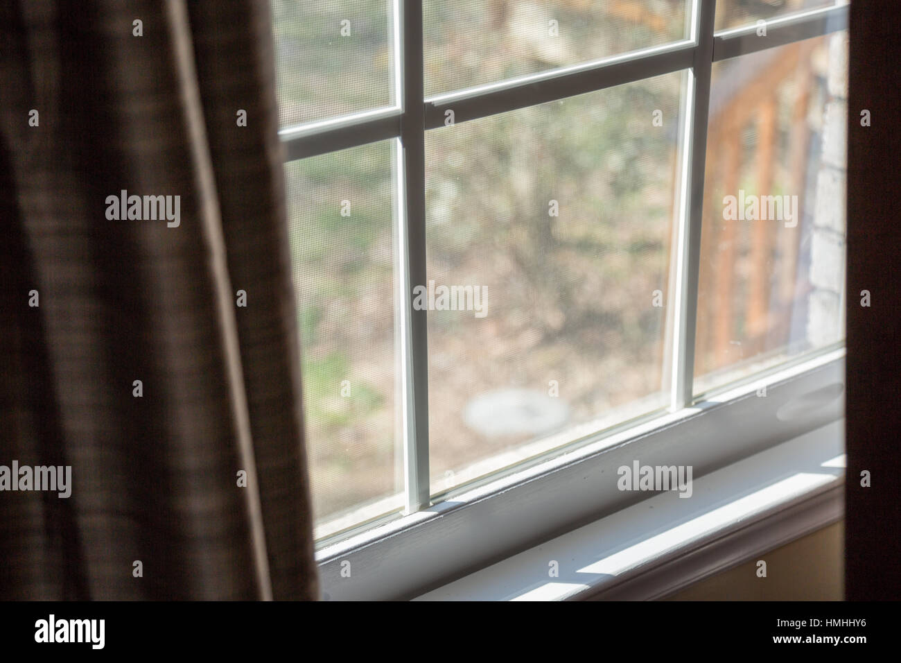 A naturally lit window sill and hanging curtains. Stock Photo