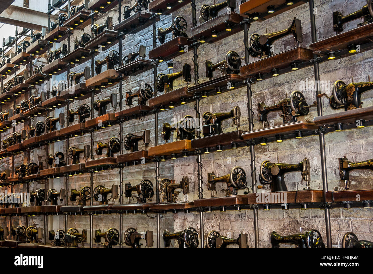 Old sewing machines on a wall in a shop Stock Photo