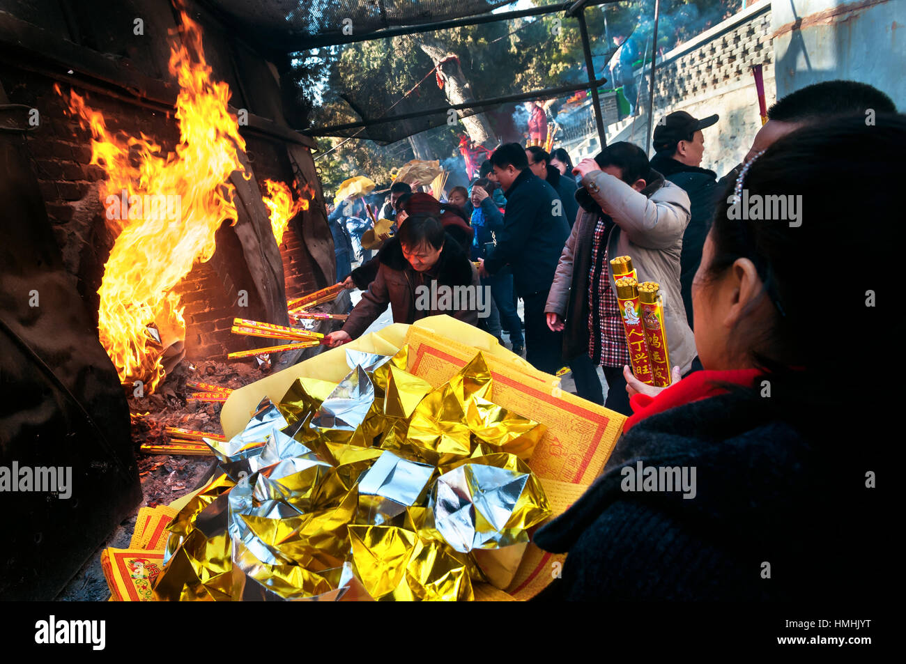 TAISHAN, CHINA - JAN 1, 2014 - Worshippers burning joss paper at a temple on Taishan mountain, China, wishing for good fortune for the new year Stock Photo