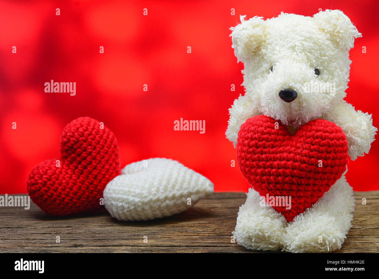 Teddy Bear Holding A Heart Shaped On Wooden Table With Red Background Stock Photo Alamy
