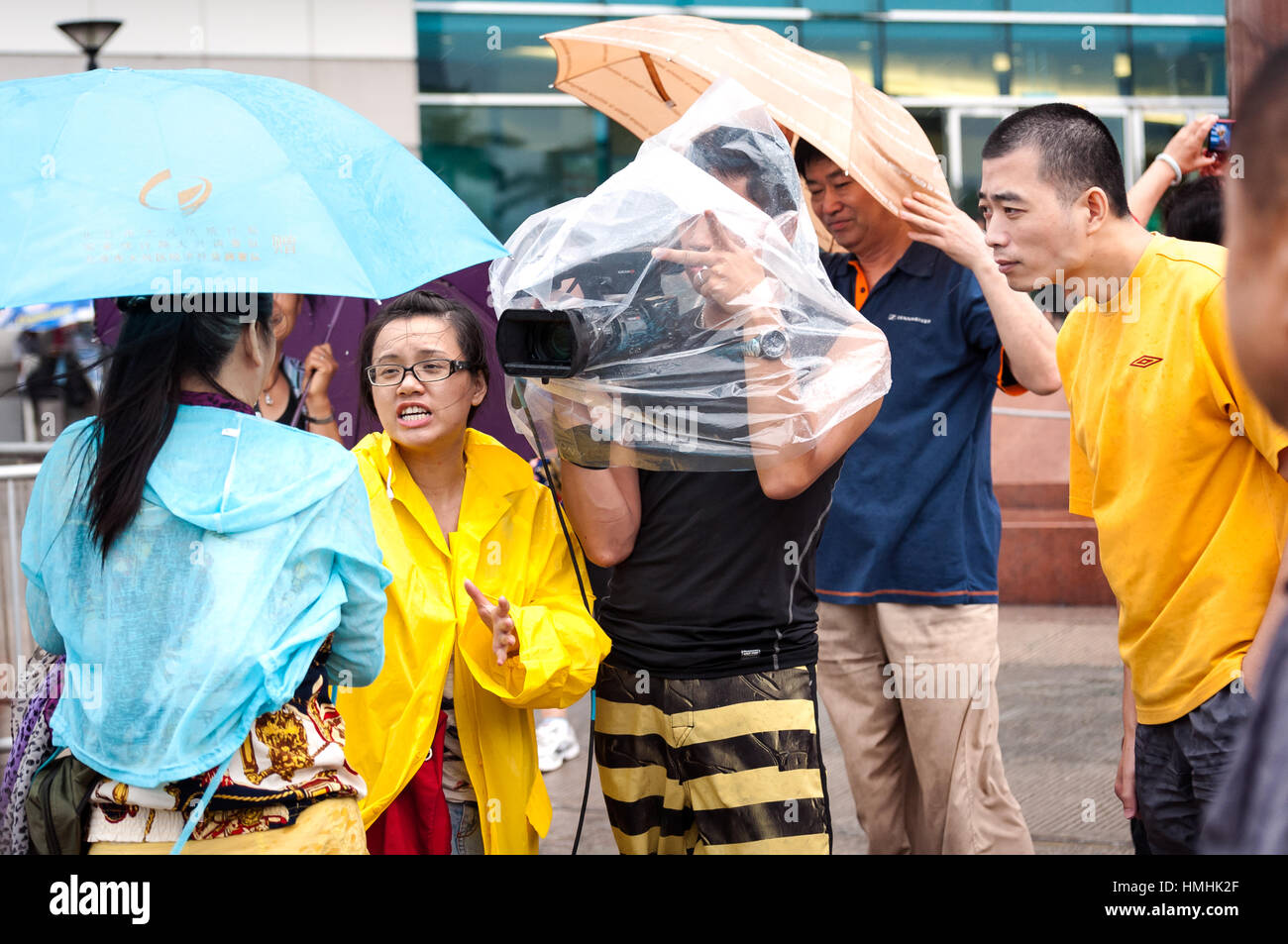 WANCHAI, HONG KONG - SEPT 22, 2013 - A reporter interviews a Chinese tourist outside the Wanchai exhibition centre as a typhoon approaches Hong Kong Stock Photo