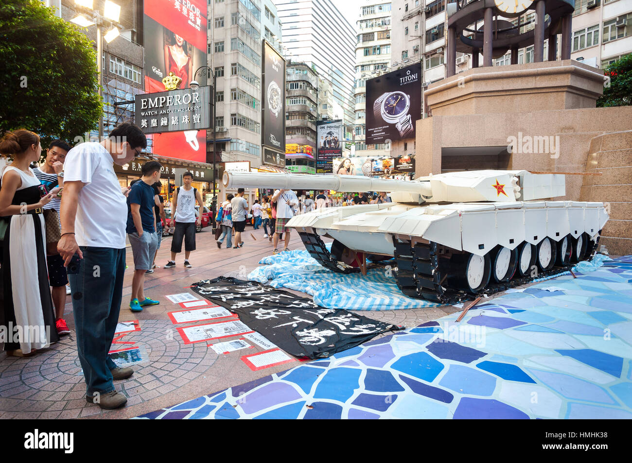 CAUSEWAY BAY, HONG KONG - JUNE 4, 2014 - A group of Chinese tourists next to a model of Chinese tank at Times Square, Causeway Bay, Hong Kong Stock Photo
