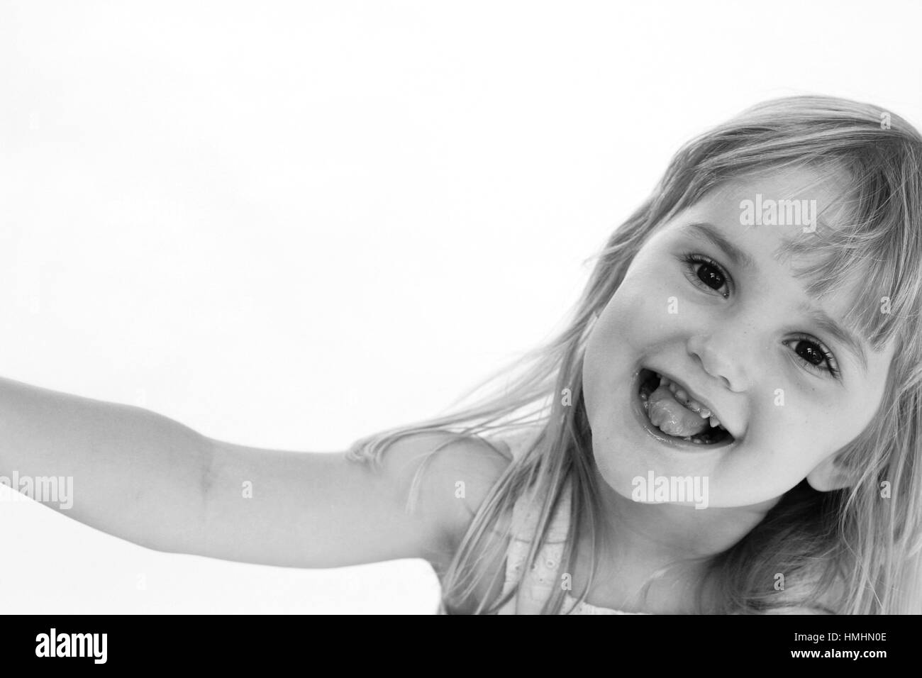 young girl smiling / child making a funny face sticking tongue out Stock Photo