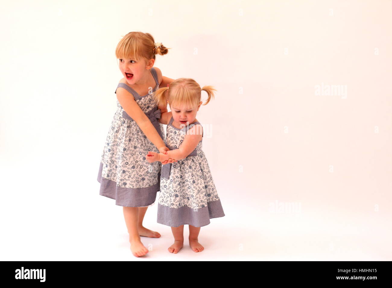 Two little girls dancing together holding hands Stock Photo Alamy