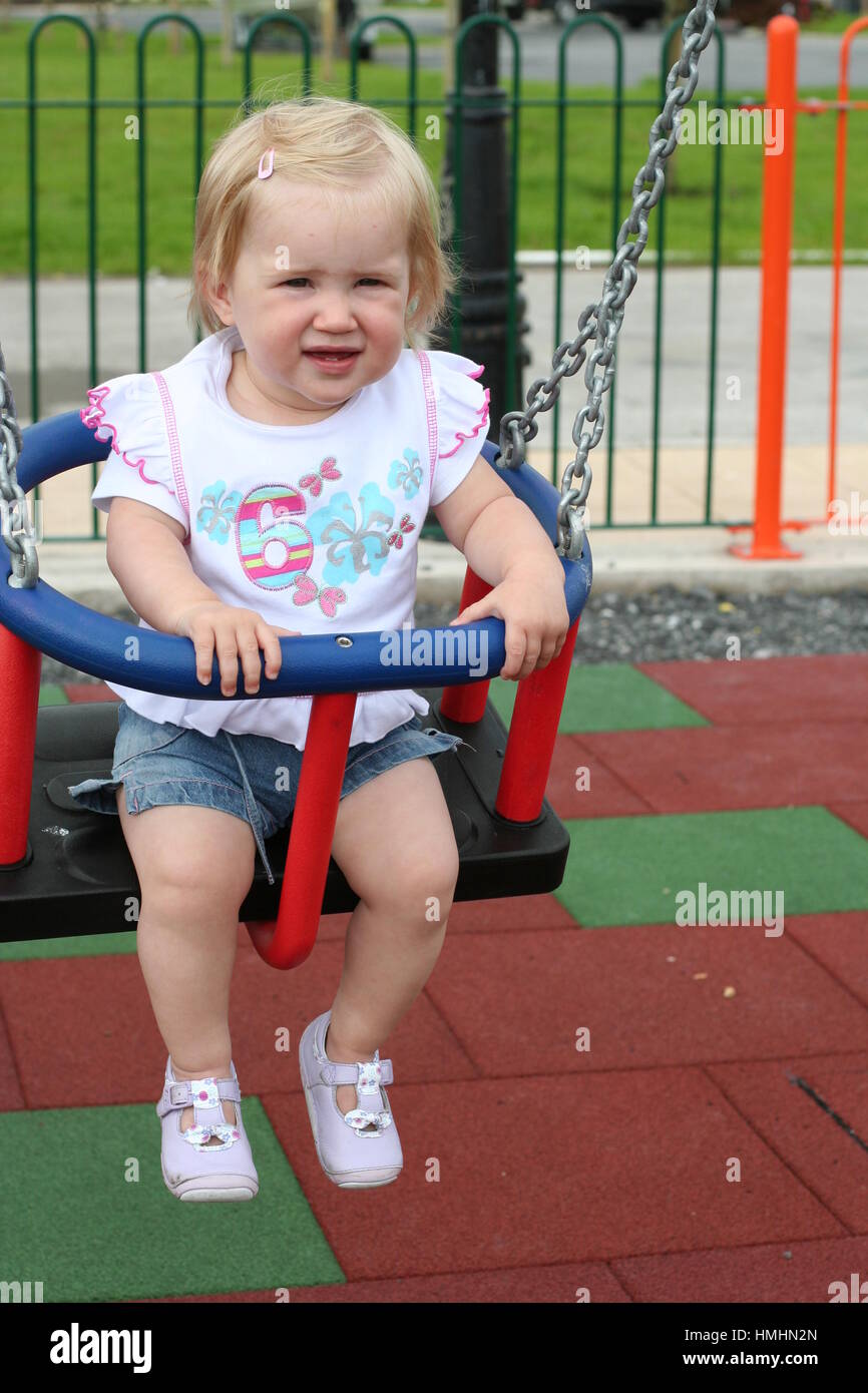 Children, kid, child having great fun playing on the swing, swings in