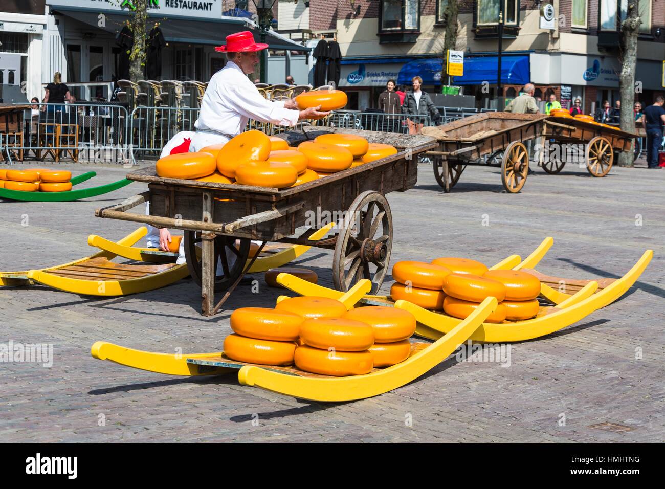 Guild cheeseporter sorting through lots of cheeses at the famous cheese market in Alkmaar, The