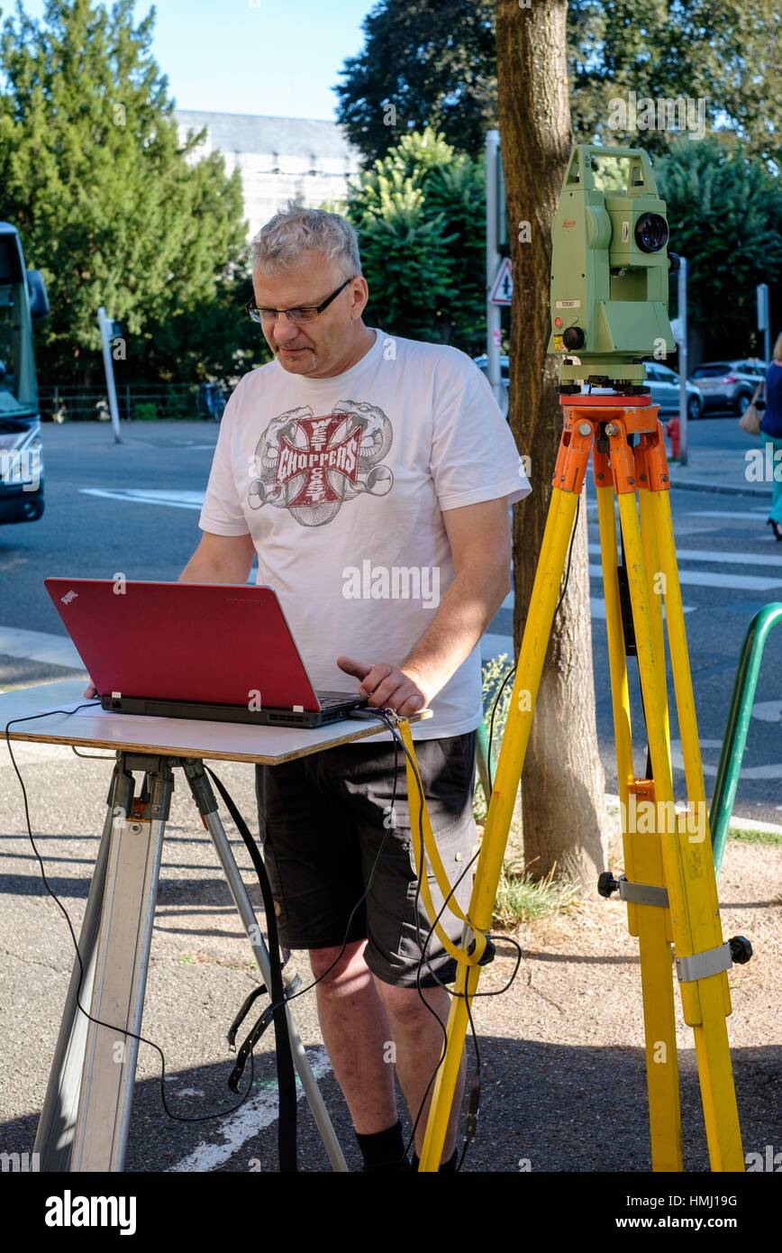 Land surveyor taking measures with Leica TCR 307 theodolite and laptop  computer. - Stock Image
