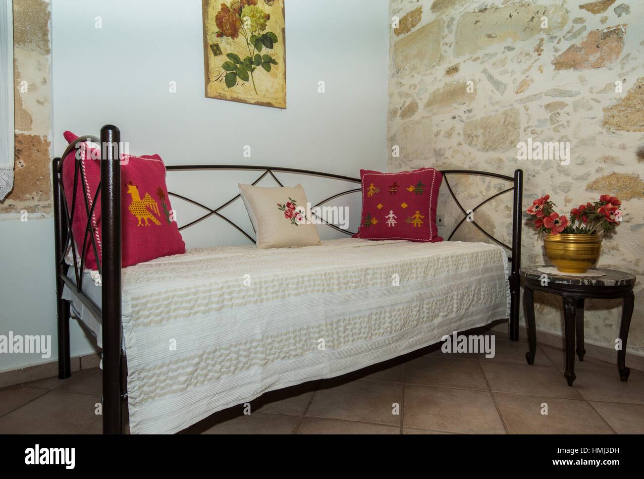 A bed in a bedroom of a traditional stone house in Crete, Greece Stock