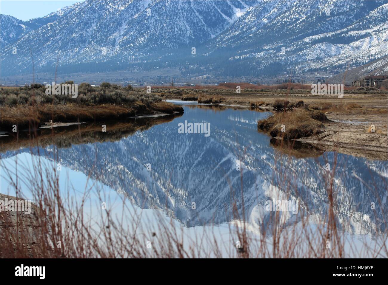 The eastern side of the Sierra Nevada mountains reflect in a pond located in the Carson Valley, near Genoa, Nevada, USA Stock Photo