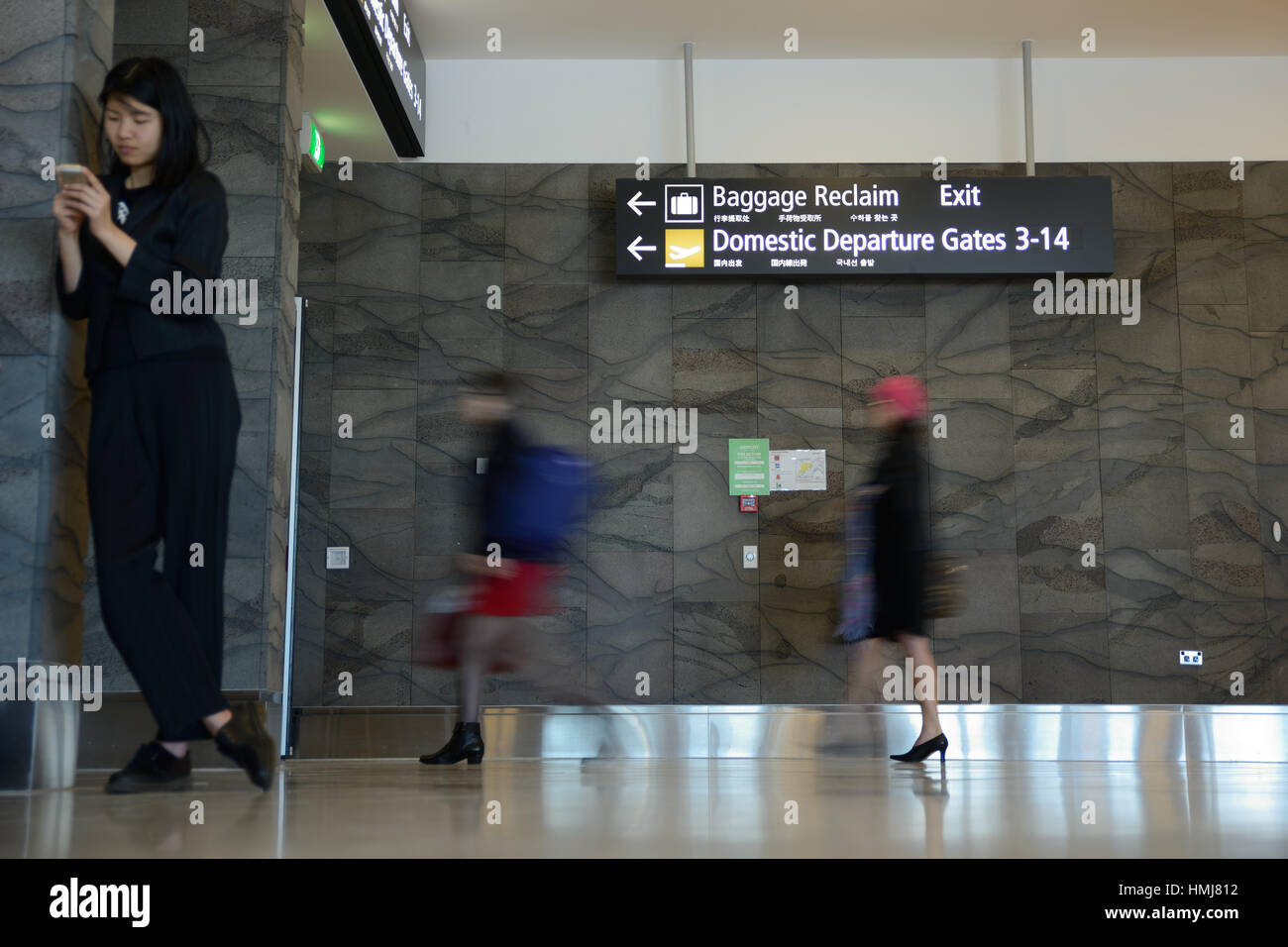 Passengers head for the domestic departures gate at an airport. Slow shutter speed for blurred motion. Stock Photo