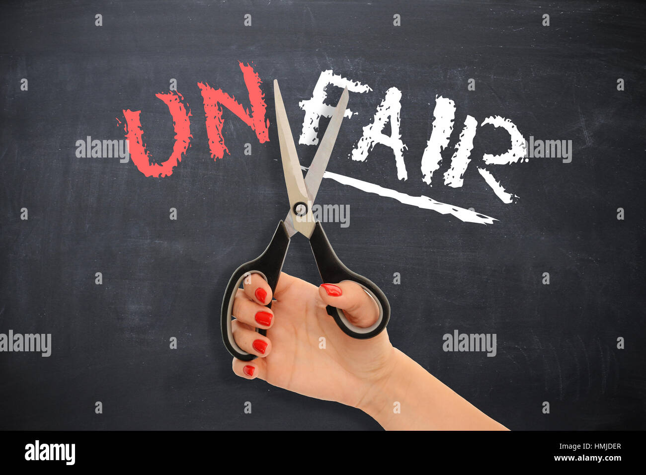 Woman doing justice to herself by cutting the word “unfair” , changing into fair Stock Photo