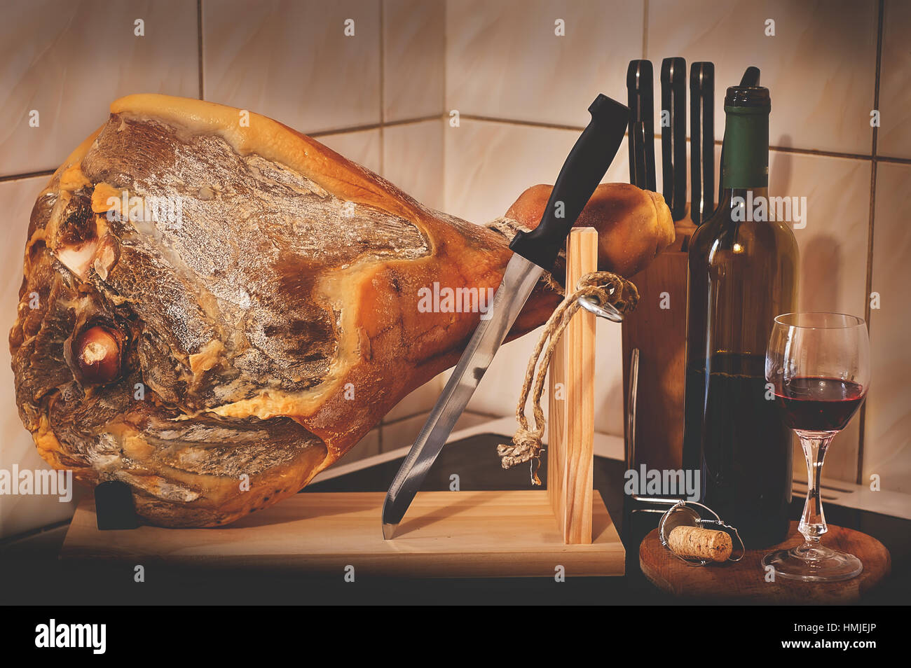 Spanish Jamon Serrano, tabla jamonera, jamonero knife with glass and bottle  of wine. Food photo concept Stock Photo - Alamy