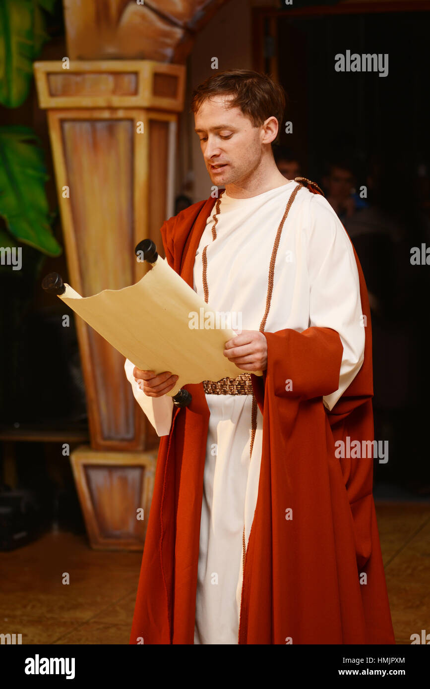 A character dressed in Roman costume reads from a scroll Stock Photo
