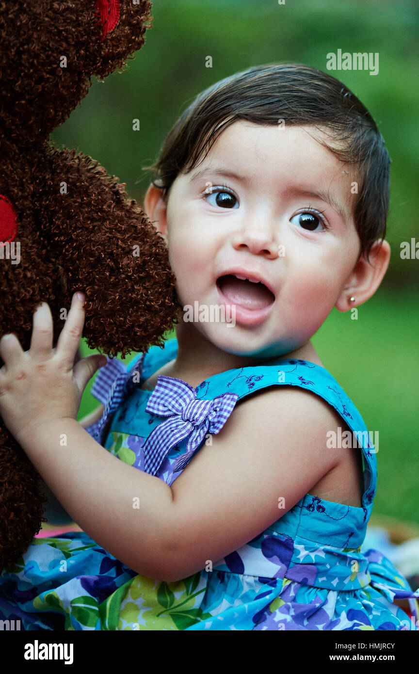 small kid girl hug toy teddy bear in green garden Stock Photo Alamy
