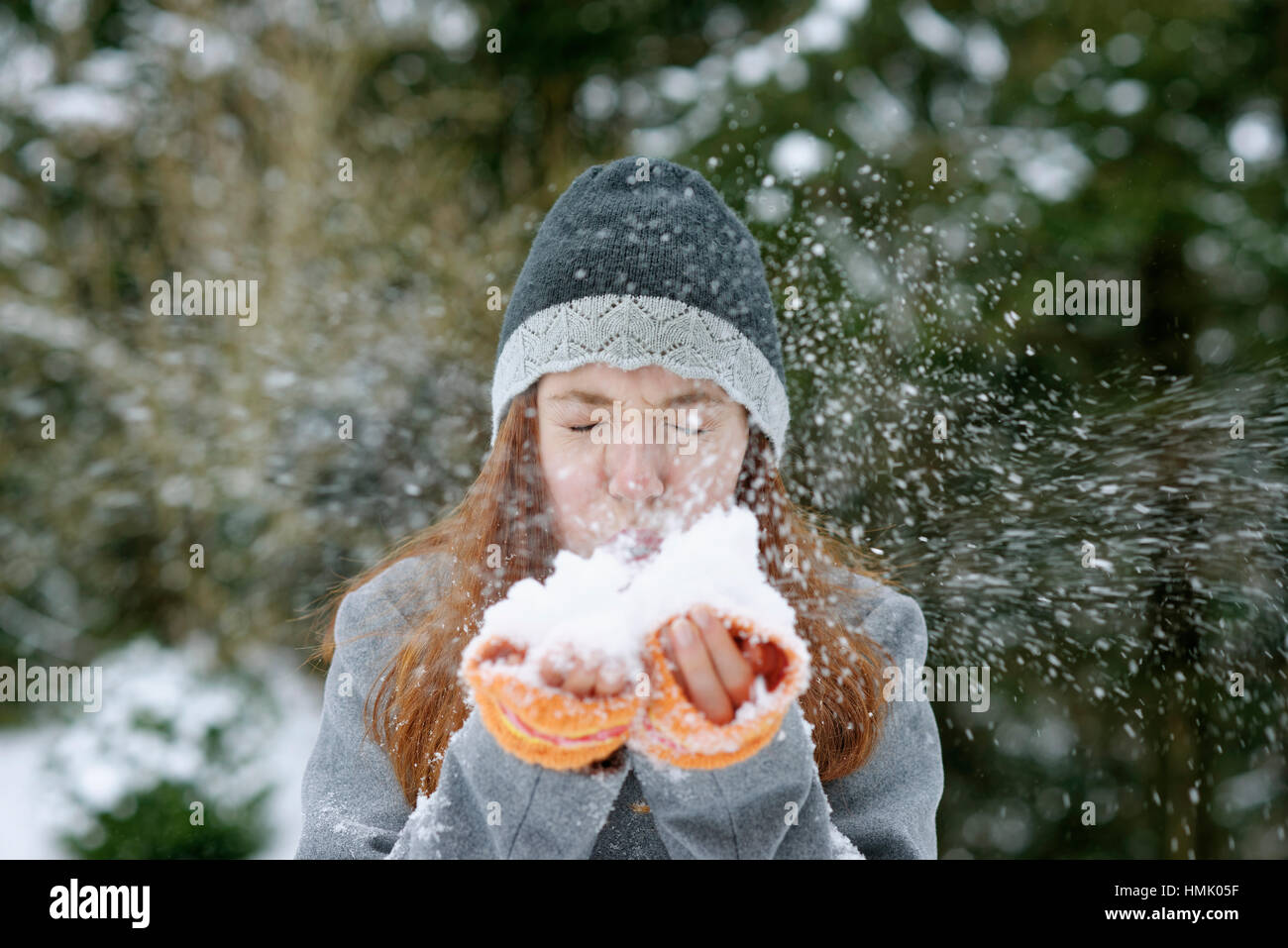 Girl blowing snow from hands, Winter, Bavaria, Germany Stock Photo