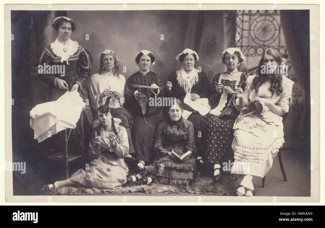 Funny postcard of studio shot of creative Edwardian women's craft crafting crafts circle in the early 1900's, possibly in fancy dress of Victorian times, England UK U.K. Stock Photo
