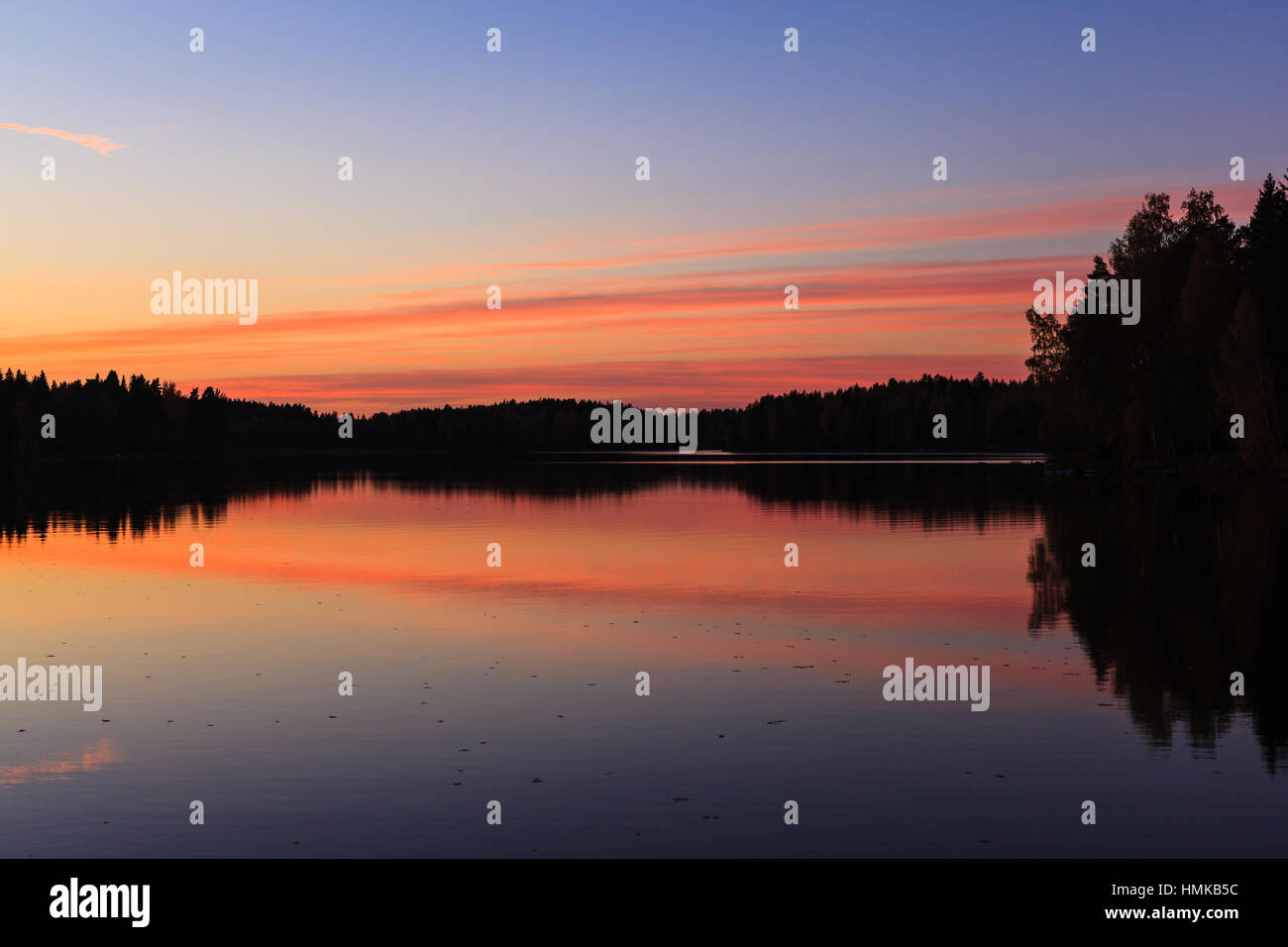 Serene view of calm lake and sunset clouds Stock Photo